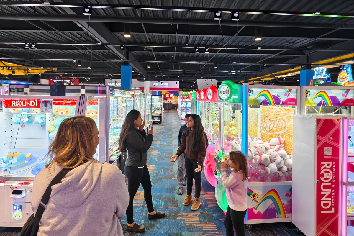 Customers engaging with claw machines in a commercial arcade venue
